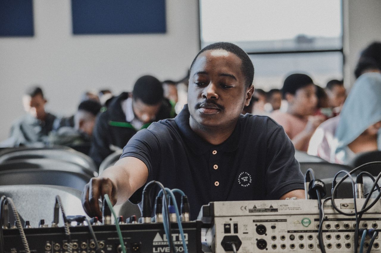 services-09 Man adjusting audio equipment in a classroom setting during a training session.
